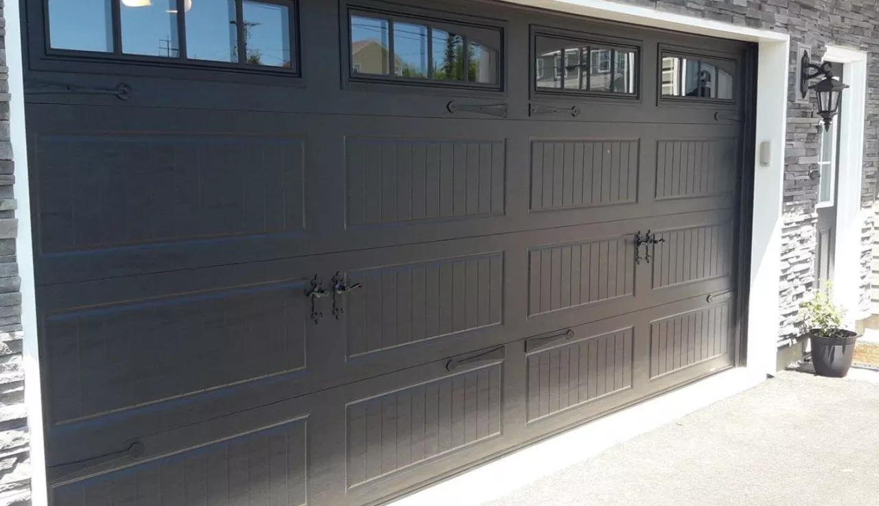 A garage door featuring elegant black trim and windows, enhancing the overall aesthetic of the property.