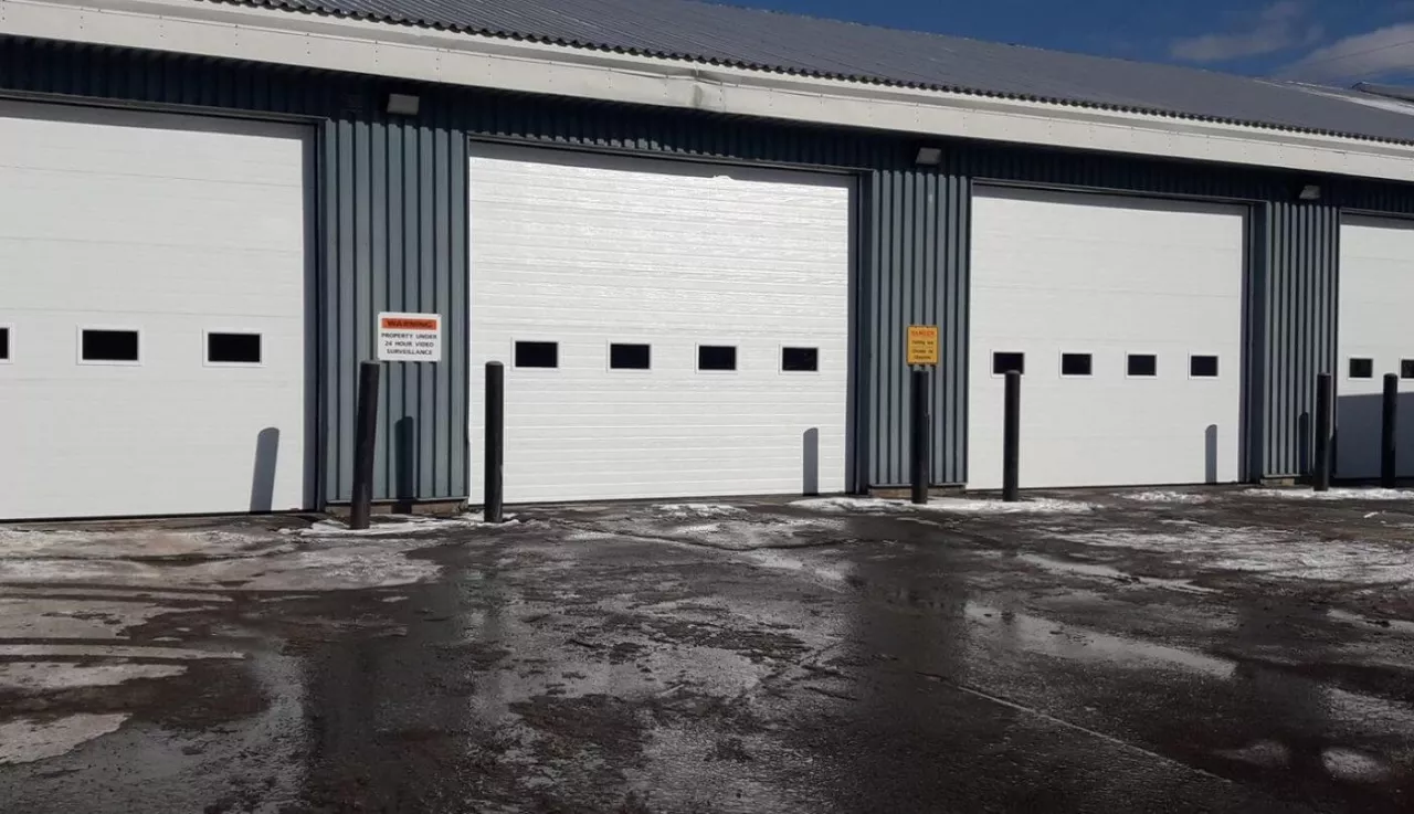 A spacious garage featuring four large doors, designed for ample vehicle storage and easy access.